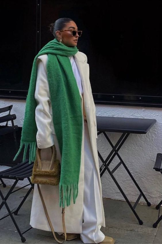 a neutral look with a white t-shirt and trousers, neutral boots and a maxi coat, a faux fur bag and a bold green scarf