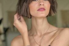 a short light brunette bob with a bit of waves and curtain bangs is a lovely idea that looks cute and cool