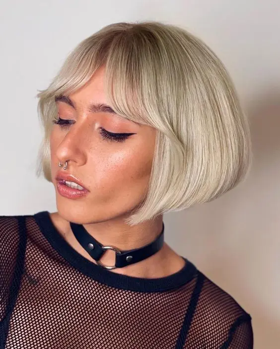 a sleek blonde angled ear-length bob with curtain bangs is a bold and very edgy idea thanks to the straight volume and angle