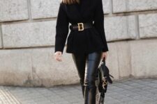 a super chic and stylish total black work look with a black sweater, a black cropped coat and a belt, leather pants, cowboy boots and a bag