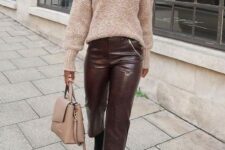 a tan oversized sweater, burgundy leather cropped pants, black boots, a blush bag for a chic and simple work look