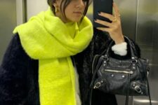 a total black look with a faux fur jacket and jeans, a bag and a neon yellow scarf are amazing for winter