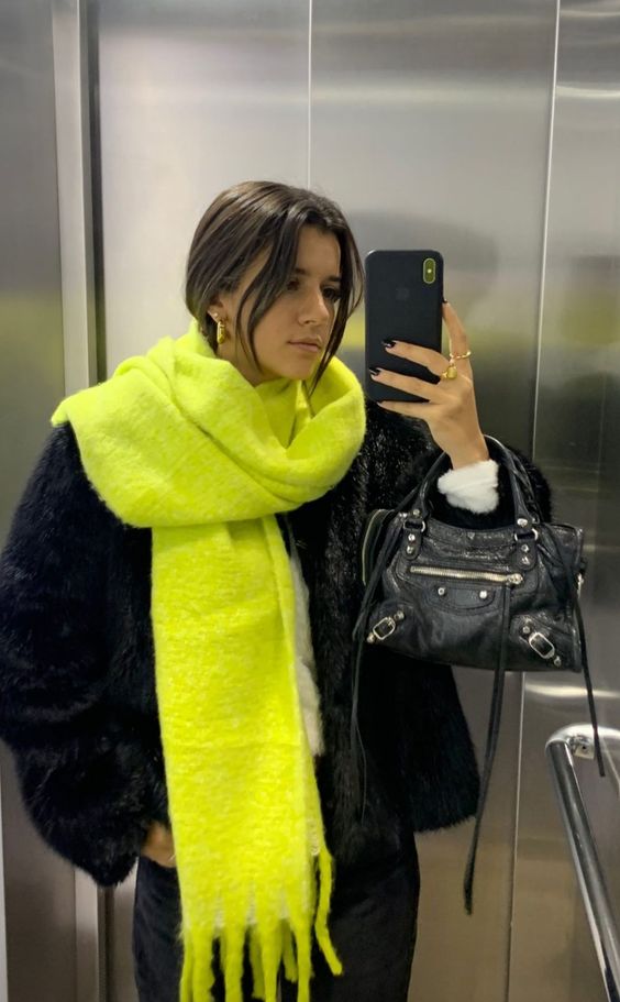 a total black look with a faux fur jacket and jeans, a bag and a neon yellow scarf are amazing for winter