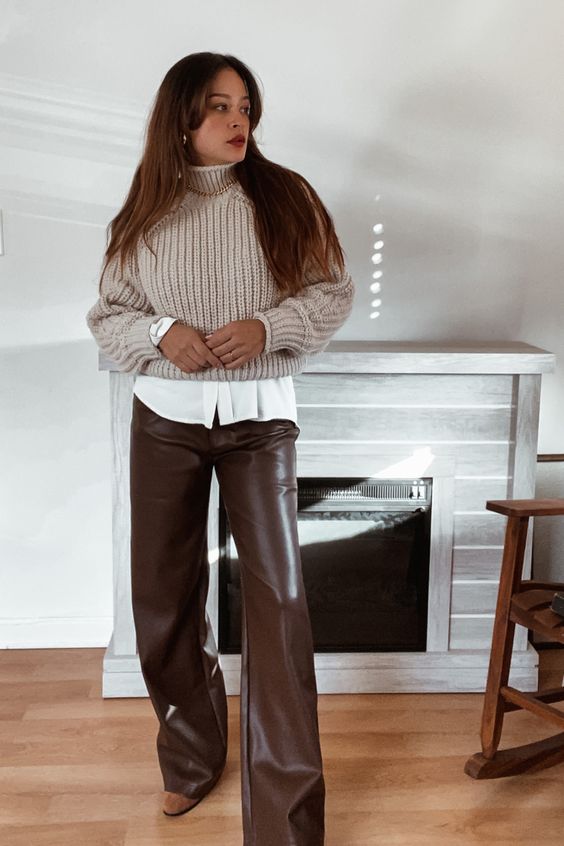 a white shirt, a grey cropped jumper over it, brown flare leather pants, beige booties and a chain necklace