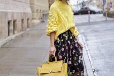 a yellow sweater with patterned sleeves, a black floral midi skirt, black lacquer boots and a yellow tote