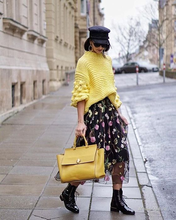 a yellow sweater with patterned sleeves, a black floral midi skirt, black lacquer boots and a yellow tote
