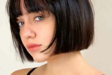 an elegant black chin-length bob with wispy bangs is a classy idea, this length matches many face shapes, and bangs are airy