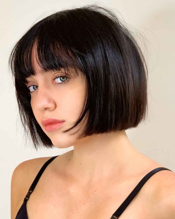 An elegant black chin length bob with wispy bangs is a classy idea, this length matches many face shapes, and bangs are airy
