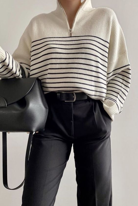 an elegant monochromatic look with a Breton stripe zip sweater, black trousers, a black bag for the fall or winter