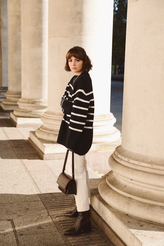 an oversized black Breton stripe sweater, white jeans, brown boots and a brown bag are a lovely combo for the fall
