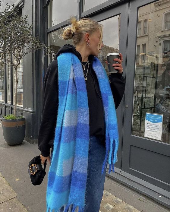 blue jeans, a black hoodie, a black bag and a bold blue oversized scarf are a great idea for fall or winter