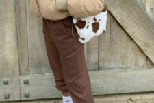 brown sweatpants, white sneakers and socks, a beige cropped puffer jacket and an animal print bag