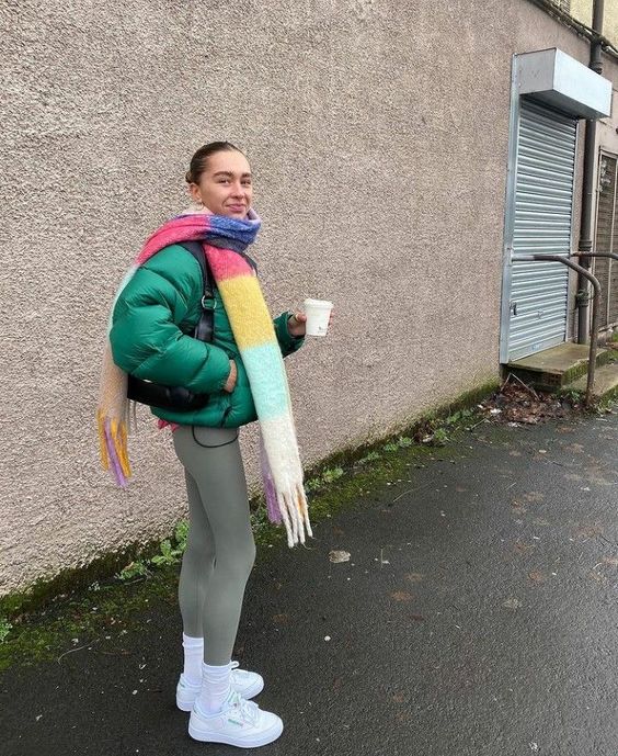 green leggings, a bold green puffer jacket, white trainers and socks and a colorful scarf are a cool combo to rock