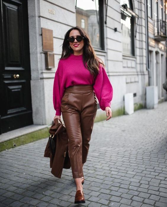 a stylish winter outfit with a magenta sweater, brown high waisted leather pants and a jacket, brown shoes and a bag