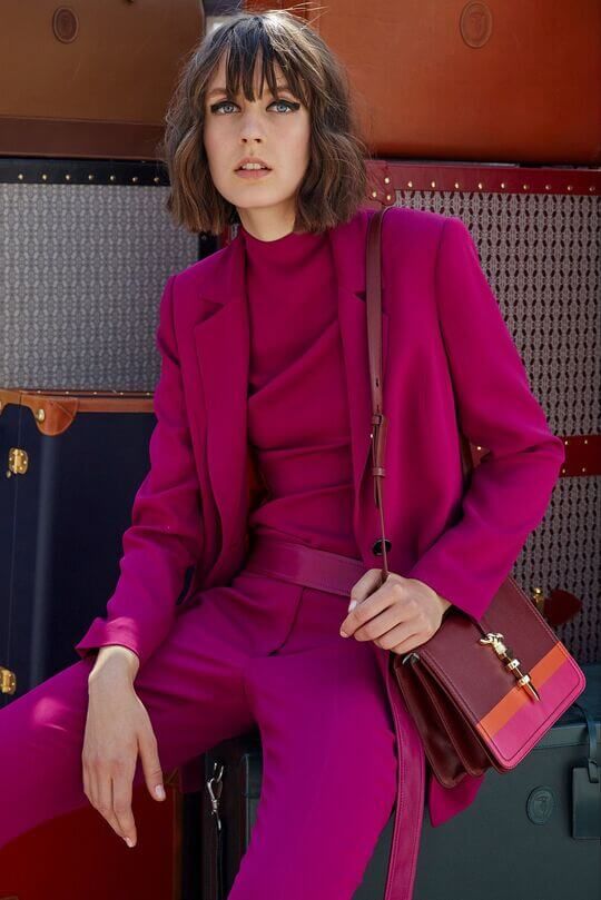 a full magenta look with a turtleneck, pants, an oversized blazer, a striped bag is a bold and cool idea for work