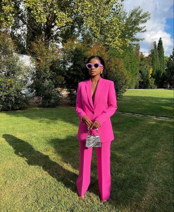 a magenta pantsuit with an oversized blazer, a printed mini bag and sunglasses in a lilac frame are a nice and bold look