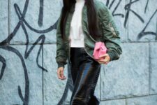 12 a white turtleneck, black croco leather pants, black boots, a green bomber jacket and a pink bag are a bold and cool look