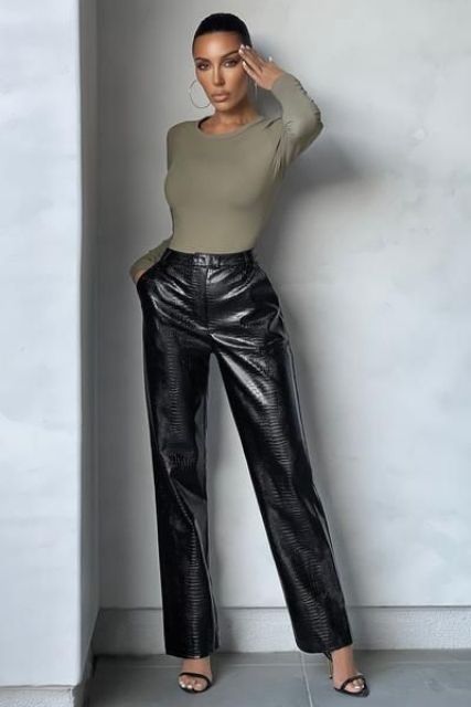 an olive green long sleeve top, black crocodile leather pants, minimalist shoes are a stylish and sexy combo