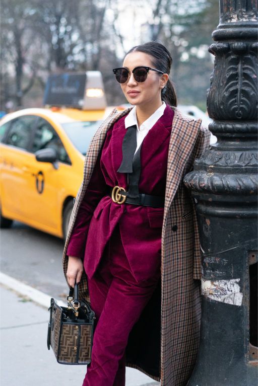 a refined work outfit with a magenta pantsuit, a white shirt and a belt, a plaid coat and a printed bag is a fantastic idea