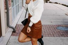 17 a white wrap up sweater, a brown croco leather mini skirt, black boots and a black bag