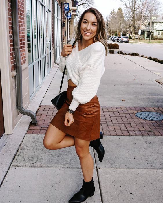 a white wrap up sweater, a brown croco leather mini skirt, black boots and a black bag