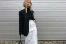 18 a trendy winter outfit with a black turtleneck and an oversized blazer, a white denim midi, snakeskin print boots and a black bag