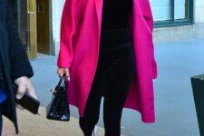 23 J.Lo wearing a total black look with leggings and a turtleneck spruced up with a magenta coat, white sneakers and a black bag