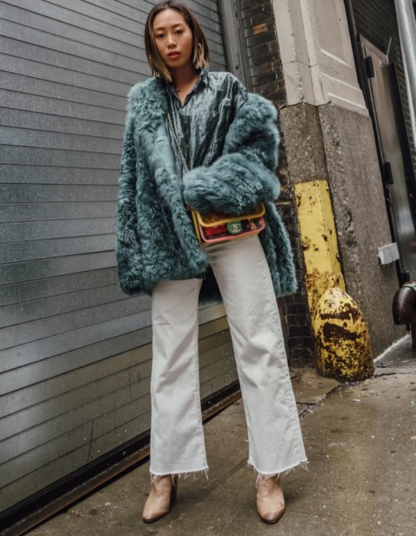 a cool winter outfit with a green shirt and a matching faux fur jacket, white jeans, nude boots and a colorful bag