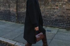 27 a total black outfit with a coat, a top and leggings, burgundy crorodile leather boots and a small matching bag
