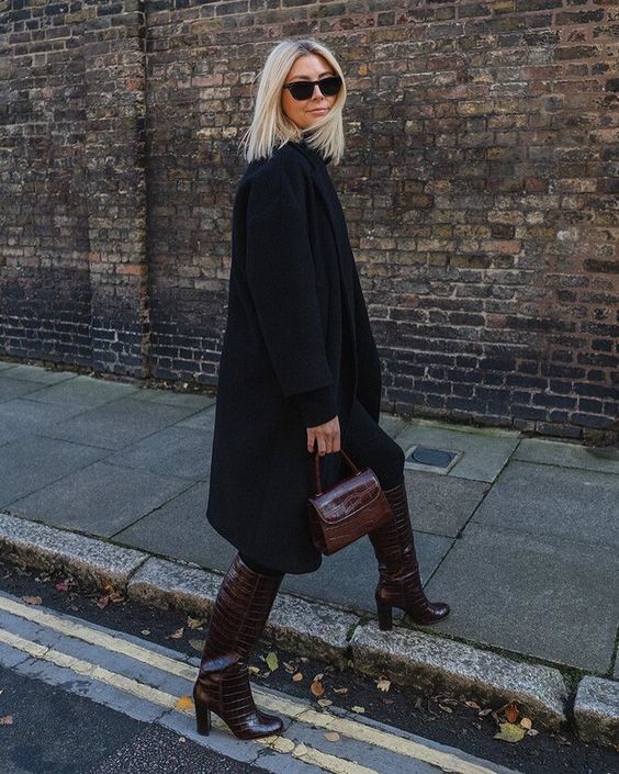 a total black outfit with a coat, a top and leggings, burgundy crorodile leather boots and a small matching bag
