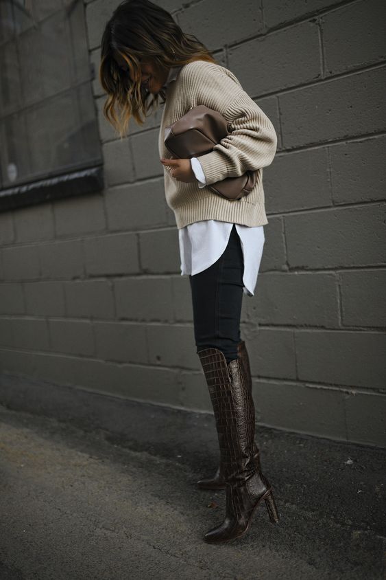 a white oversized shirt, a neutral sweater on top, black skinnies, burgundy croco leather boots and a taupe bag