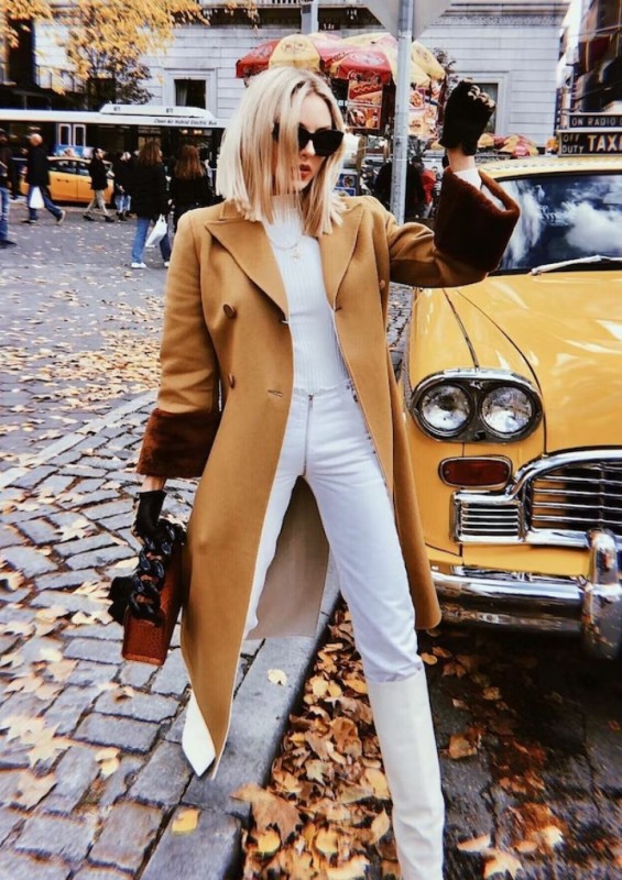 a white turtleneck, jeans, knee boots, a beige coat and an amber bag are a lovely fall or winter combo