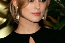 Keira Knightley wearing brunette hair with honey and blonde balayage, with long curtain bangs for a super refined and chic look