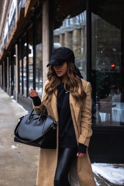 With black sweatshirt, black leather leggings and black leather tote bag