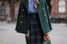 With blue and white button down blouse, rounded sunglasses, black, blue and red checked belted high-waisted midi skirt, brown leather gloves and green leather rounded bag