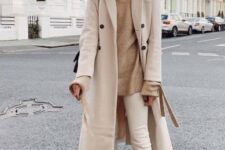 With light brown loose turtleneck sweater, beige skinny pants, beige suede mid calf boots and black bag