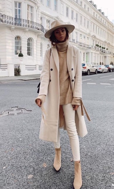 With light brown loose turtleneck sweater, beige skinny pants, beige suede mid calf boots and black bag