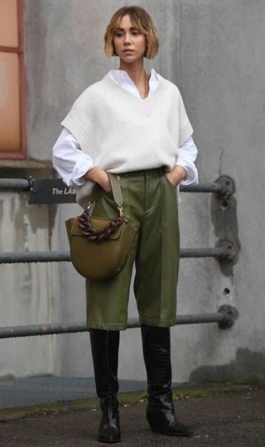 With white button down loose shirt, black leather high boots and olive green leather bag