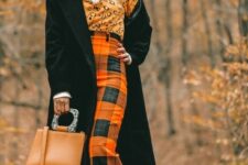 With white turtleneck, leopard printed shirt, orange and black checked high-waisted midi skirt, earrings, sunglasses, brown leather bag and black patent leather mid calf boots