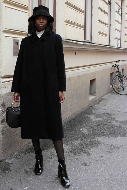 With white turtleneck, skirt, black leather bag and black patent leather mid calf boots