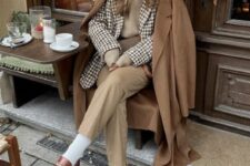 a beautiful layered winter work look with a white shirt, a tan waistcoat, a printed blazer, tan trousers, white socks, brown loafers and a brown coat