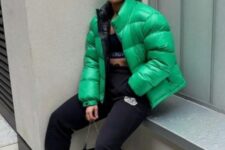 a blck crop top, black sweatpants, green and white trainers and an emerald puffer jacket for a sport chic winter look