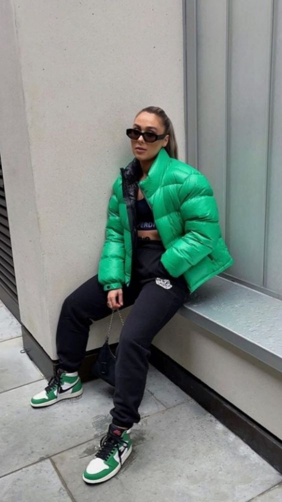 a blck crop top, black sweatpants, green and white trainers and an emerald puffer jacket for a sport chic winter look