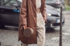 a bold and neutral outfit with a jumpsuit with a wide belt, snakeskin print boots, a brown leather puffer coat and a brown bag