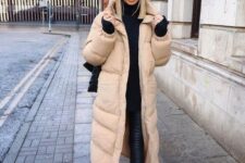 a bold contrasting outfit in black, with a tan puffer coat that refreshes the look and makes it more eye-catchy