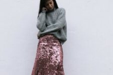 a casual holiday look with an oversized grey sweater, a pink sequin midi skirt, white sneakers and statement earrings