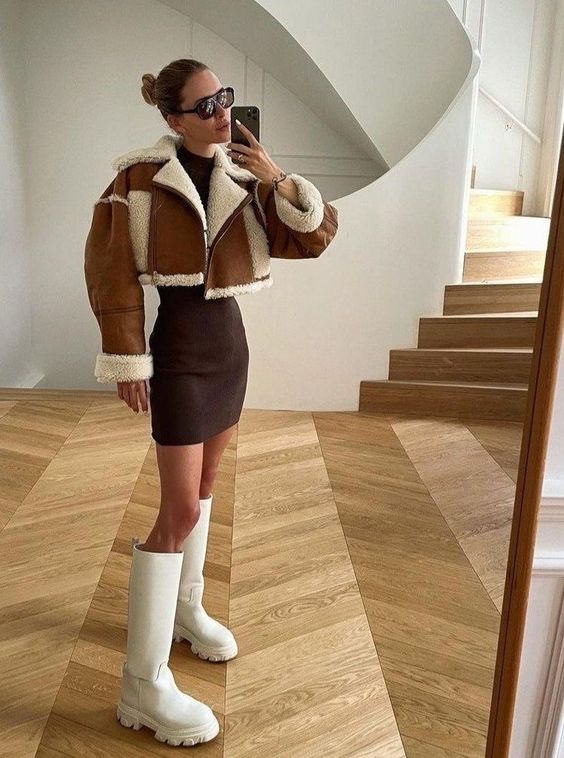 a chic and bold winter outfit with a brown bodycon dress, a cropped shearling jacket and creamy knee boots