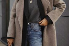 a comfy layered winter work look with a grey top, a black oversized blazer, blue jeans, a beige coat and a black bag plus layered necklaces