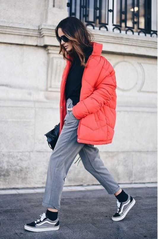 a cozy winter outfit with a black turtleneck, grey trousers, black sneakers and a coral puffer jacket, a black bag