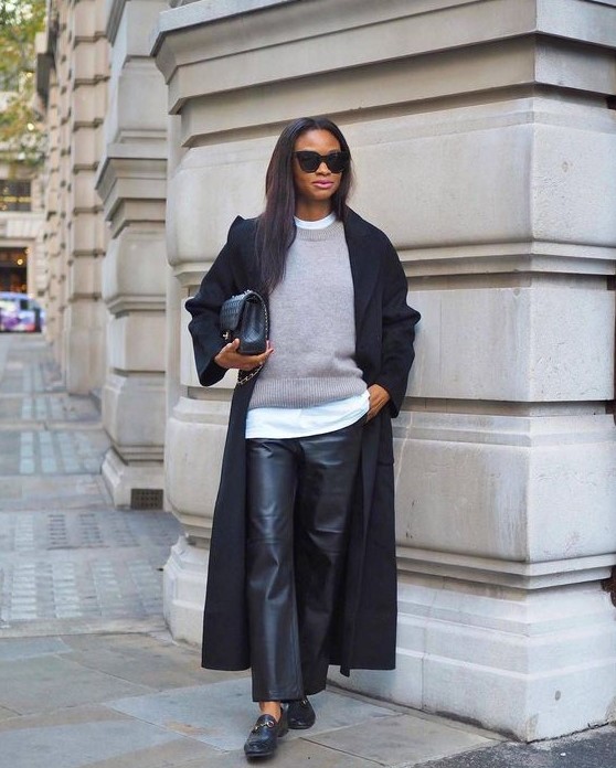 a layered monochromatic look with a white t-shirt, a grey jumper, black leather trousers, black flats, a black coat and a bag